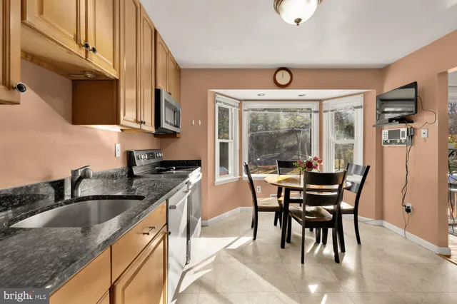 a kitchen with stainless steel appliances granite countertop a sink a stove and a refrigerator with wooden floor