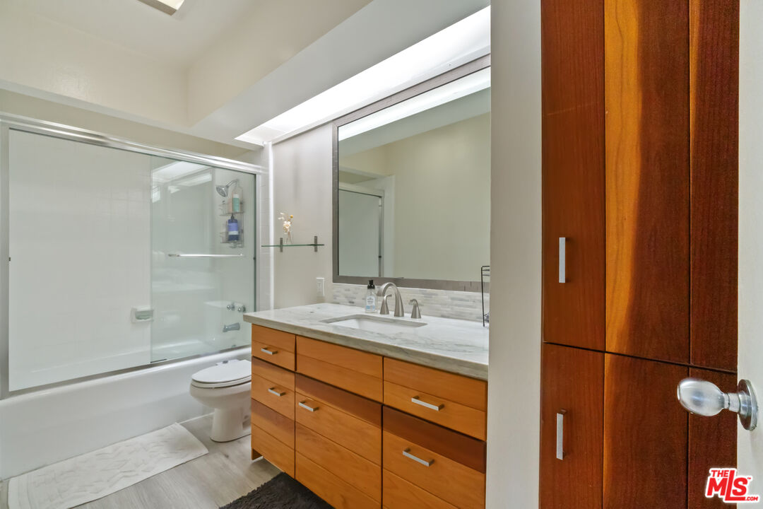 6209 Pacific Avenue, Unit 103 Playa del Rey, CA 90293 - Photo 20 of 40 a bathroom with a double vanity sink toilet mirror and shower