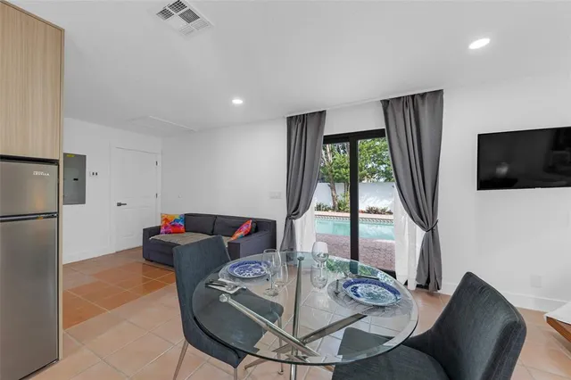 a living room with furniture a flat screen tv and a large window