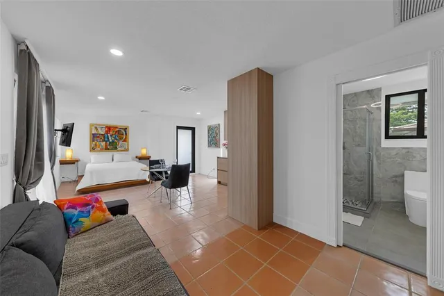 a living room with furniture and a view of bathroom