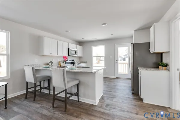 a kitchen with granite countertop a sink cabinets and wooden floor