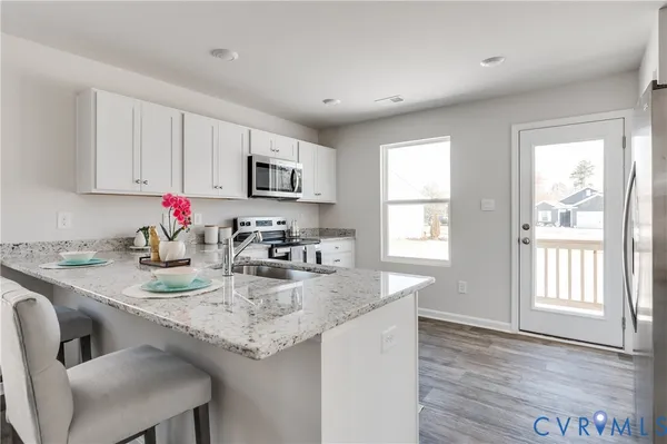 a kitchen with a table chairs refrigerator and cabinets