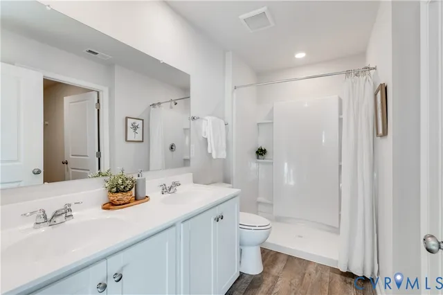 a bathroom with a granite countertop sink a toilet and shower