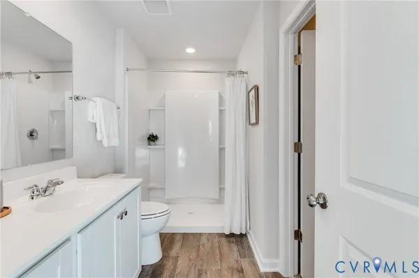 a bathroom with a granite countertop sink mirror toilet and bathtub
