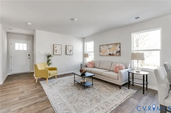 a living room with furniture a rug and a window