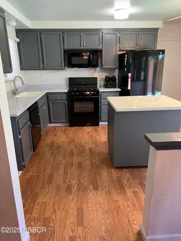 a kitchen with stainless steel appliances a stove a sink and a refrigerator