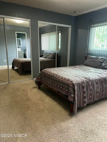 a bedroom with a bed and a mirror