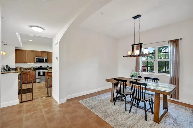 a view of a dining room and livingroom with furniture wooden floor a chandelier