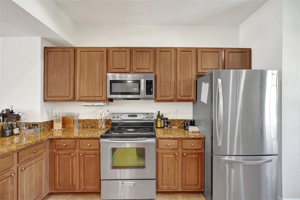 228 Southwest 6th Court Pompano Beach, FL 33060 - Photo 17 of 50 a kitchen with stainless steel appliances granite countertop a refrigerator stove a sink and dishwasher with wooden floor