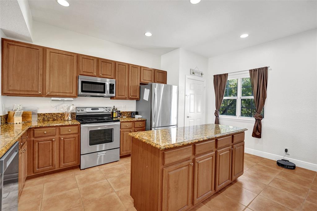 228 Southwest 6th Court Pompano Beach, FL 33060 - Photo 20 of 50 a kitchen with kitchen island granite countertop a sink stove and refrigerator