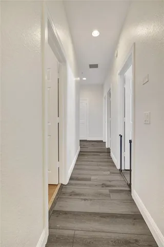 a view of a hallway with wooden floor