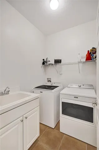 a utility room with sink dryer and washer