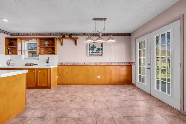 a large kitchen with stainless steel appliances a large counter top a stove a chimney a sink and a refrigerator