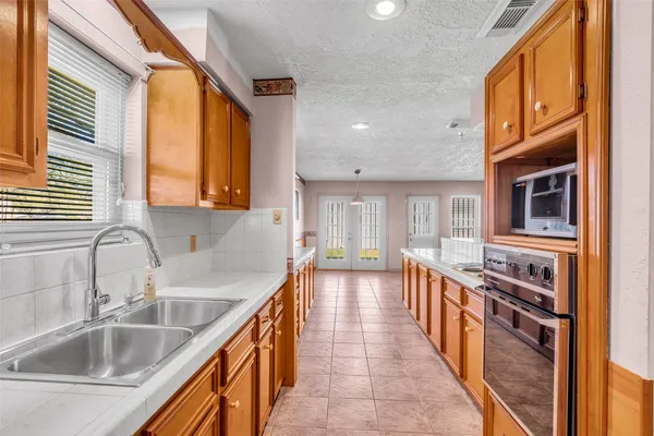 a large kitchen with stainless steel appliances granite countertop a stove a sink dishwasher and a refrigerator