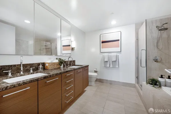 a spacious bathroom with a granite countertop sink a mirror and a bathtub