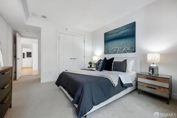 a spacious bedroom with a bed and a lamp