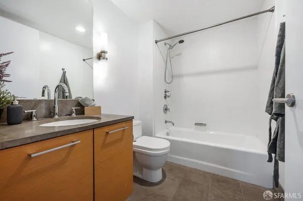 a bathroom with a granite countertop sink a toilet and shower
