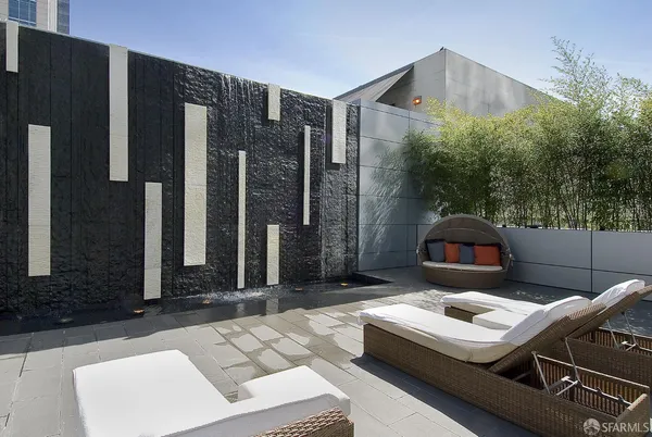 a backyard of a house with barbeque oven table and chairs