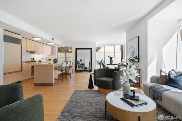 a living room with furniture kitchen view and large windows