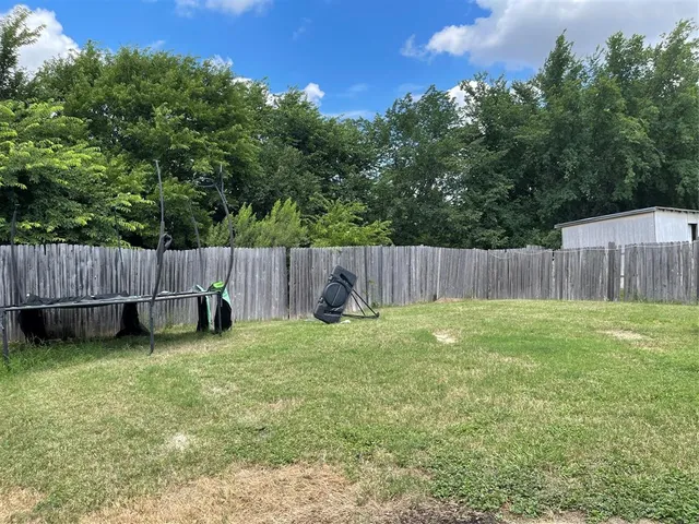 a backyard with wooden fence and a bench