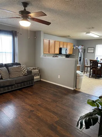 a living room with furniture and a wooden floor