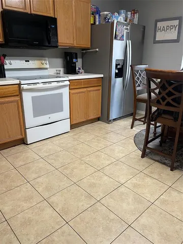 a kitchen with stainless steel appliances a stove a sink a microwave and a refrigerator