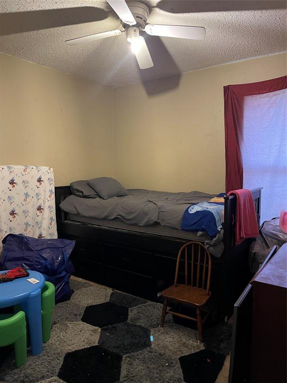 7554 Rice Lane Dallas, TX 75241 - Photo 10 of 16 a bed sitting in a bedroom next to a window with a book shelf