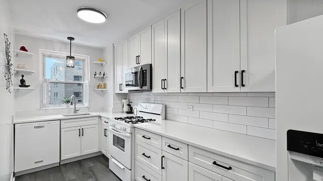 a kitchen with white cabinets and white appliances