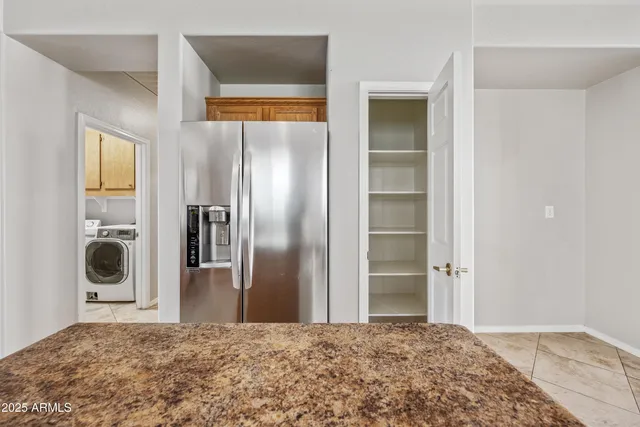 a large bedroom with a bed and a refrigerator