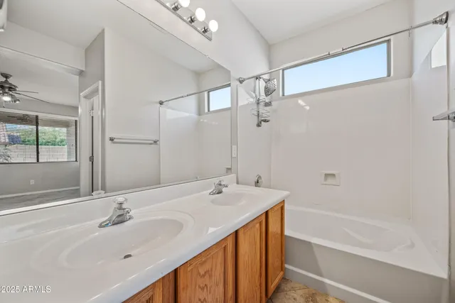 a bathroom with a tub sink and mirror