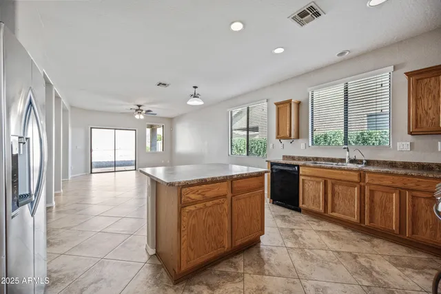 a large kitchen with kitchen island granite countertop a large counter top and stainless steel appliances