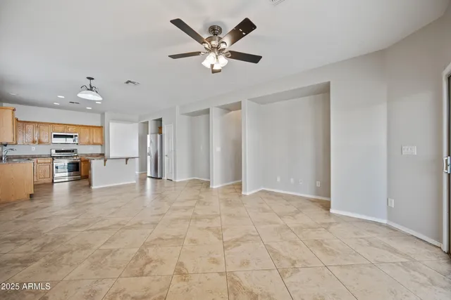 a view of an empty room with kitchen view and a window