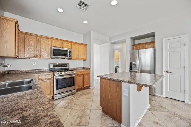 a kitchen with stainless steel appliances granite countertop a stove top oven a sink a counter top space and cabinets