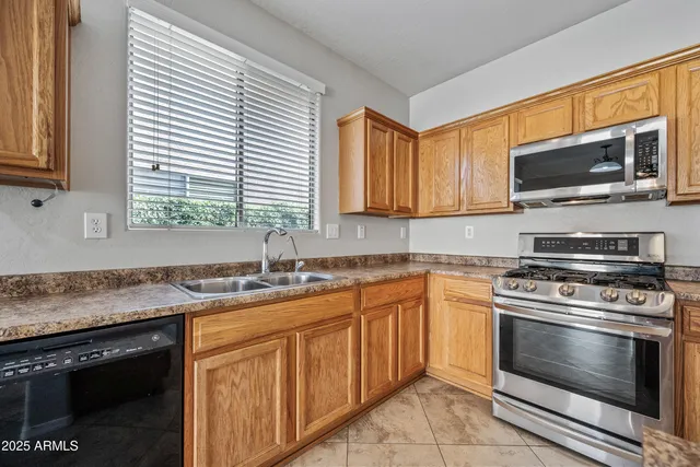 a kitchen with stainless steel appliances granite countertop a sink stove microwave and cabinets