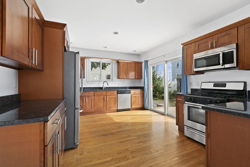 53 Prospect Avenue Winthrop, MA 02152 - Photo 6 of 18 a kitchen with stainless steel appliances granite countertop a stove a sink and a microwave