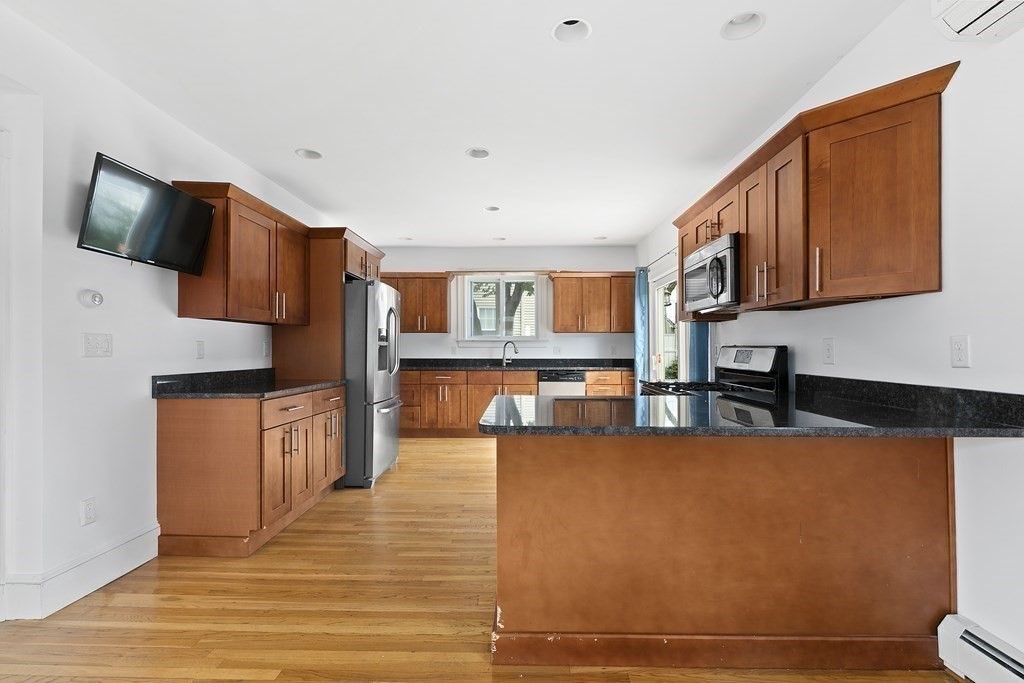 53 Prospect Avenue Winthrop, MA 02152 - Photo 7 of 18 a kitchen with stainless steel appliances granite countertop a sink wooden cabinets and a counter top space