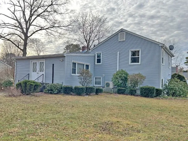 a front view of house with yard and trees around