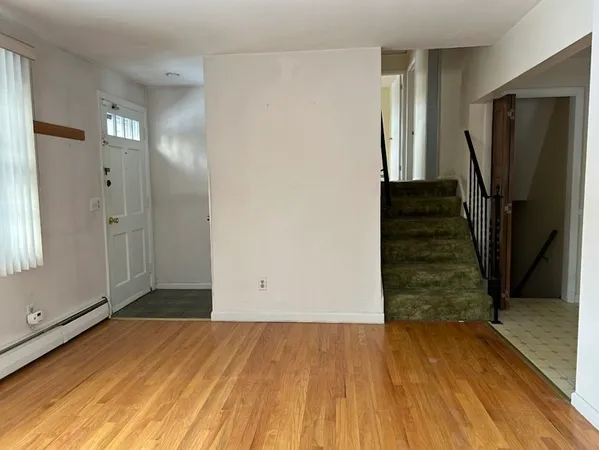 a view of a room with wooden floor and stairs