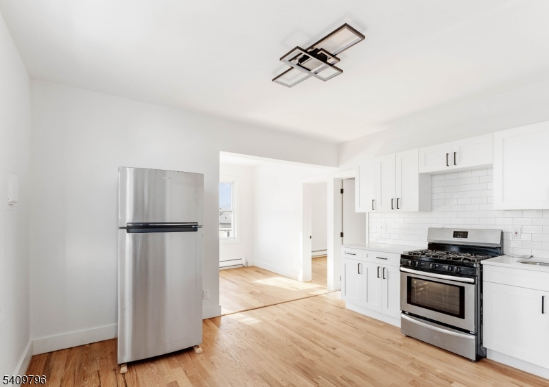 521 Bayway, Unit 1R Elizabeth, NJ 07202 - Photo 4 of 8 a kitchen with granite countertop a refrigerator and a stove top oven