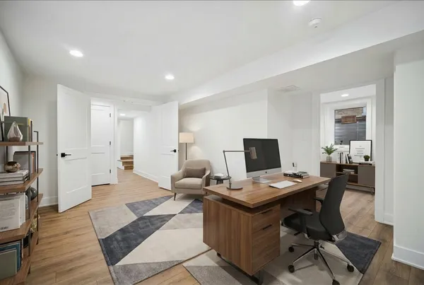 a view of a workspace with furniture and wooden floor