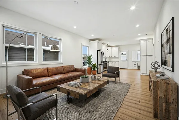 a living room with furniture a wooden floor and a flat screen tv