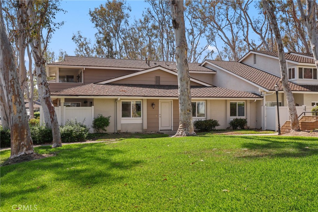 a front view of a house with a garden and trees