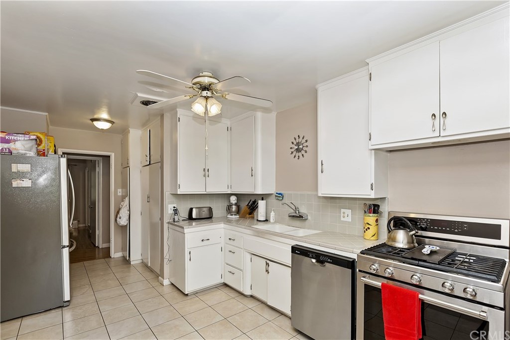 3451 Mono Drive Riverside, CA 92506 - Photo 6 of 24 a kitchen with stainless steel appliances a stove a sink and white cabinets