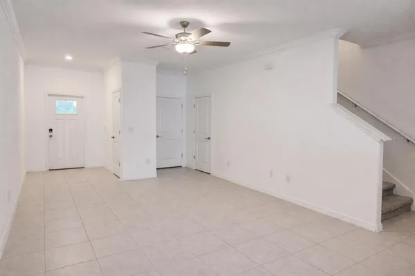 an empty room with a ceiling fan and a rug