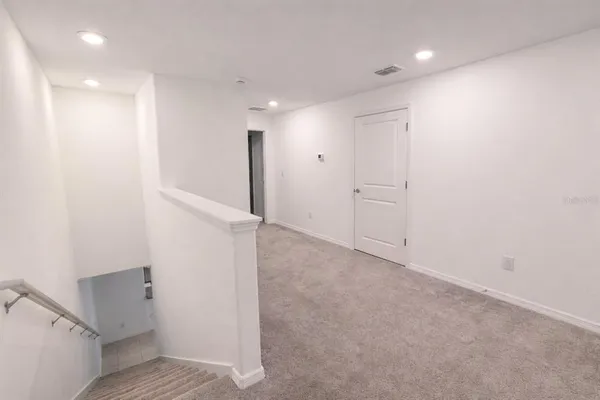 an empty room with a window and a fan