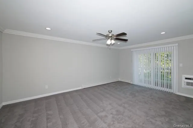an empty room with a chandelier fan and windows