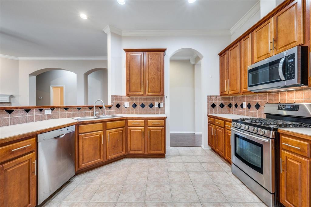 6752 Longhorn Trail Frisco, TX 75034 - Photo 6 of 12 a kitchen with stainless steel appliances granite countertop a stove and a sink
