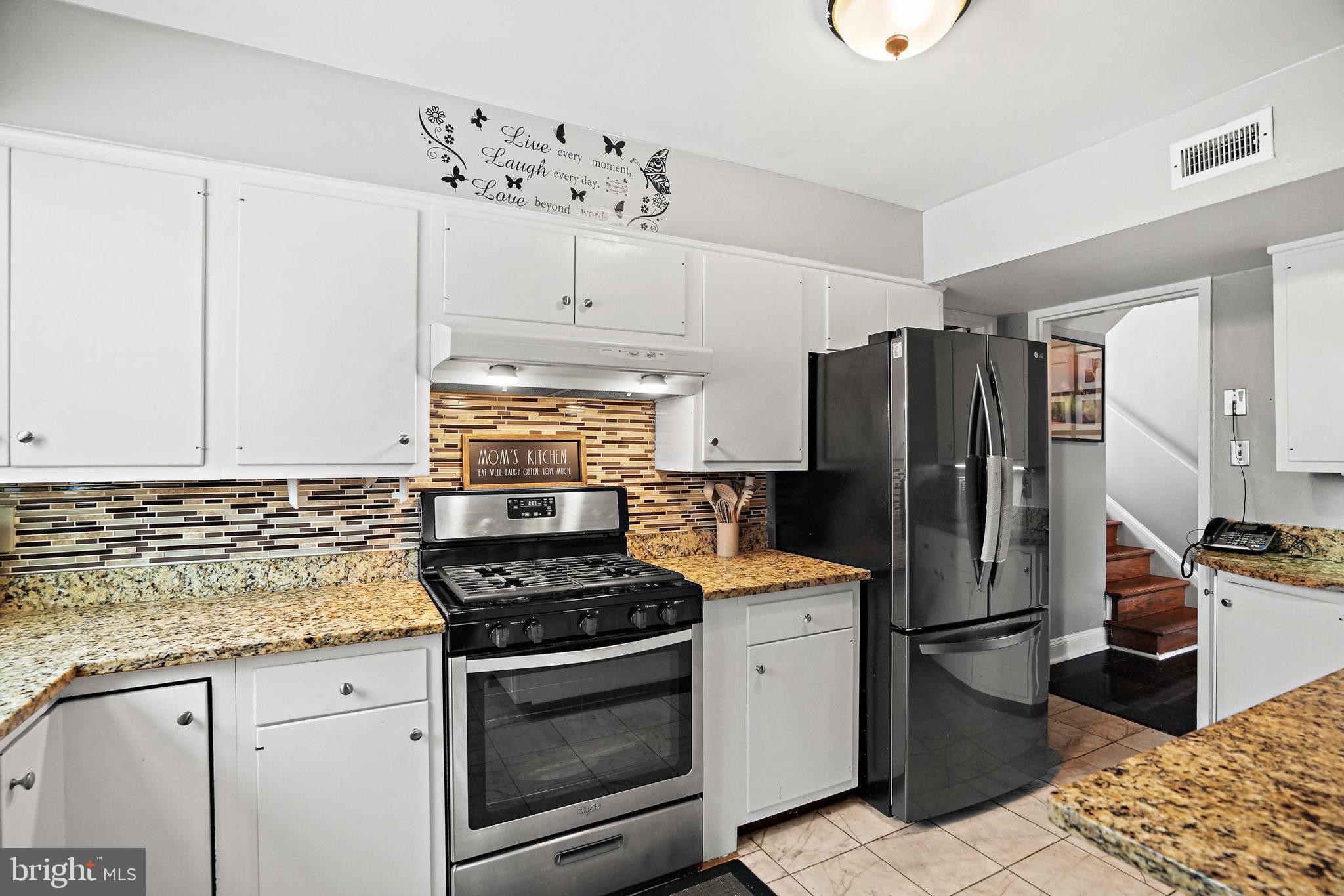 3816 Kayson Street Silver Spring, MD 20906 - Photo 15 of 44 a kitchen with granite countertop a refrigerator stove and white cabinets