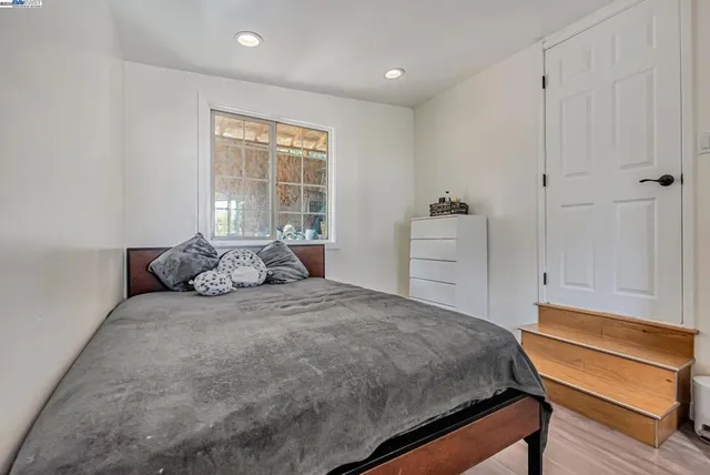a large bed sitting in a room next to a window