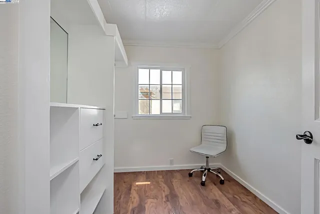 a view of a workspace with wooden floor and a window
